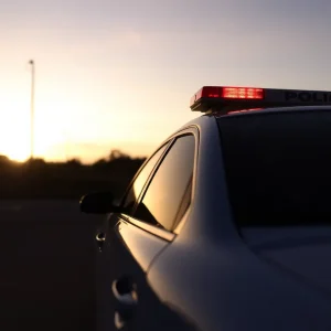 Empty police cruiser at sunset, reflecting a somber mood.